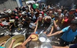 Des Palestiniens font la queue pour un repas chaud dans une cuisine caritative gérée par le Programme alimentaire mondial (PAM) des Nations unies au camp de réfugiés de Nousseirat, dans le centre de la bande de Gaza, le 26 avril 2025