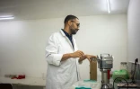 Le docteur microbiologiste Yoan Mboussou, fabrique des gélules d'iboga dans un laboratoire à Akanda, le 13 février 2025 au Gabon