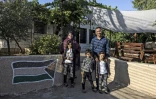 Le Palestinien Saadat Gharib et sa famille devant leur maison encerclée par les logements de colons israéliens, le 19 juillet 2022 à Beit Ijza, en Cisjordanie occupée