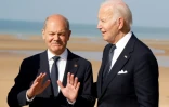 Le chancelier allemand Olaf Scholz (gauche) et le président américain Joe Biden échangent lors d'une cérémonie marquant le 80e anniversaire du Débarquement allié en Normandie, le 6 juin 2024 à Saint-Laurent-sur-Mer