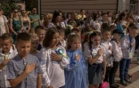 Des enfants ukraniens chantent l'hymne national avec leurs enseignants et leurs familles lors de la rentrée des classes, le 1er septembre 2023 à Irpin, dans les environs de Kiev