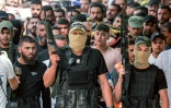 Des hommes en armes masqués accompagnent un cortège, le 12 juin 2024, lors des funérailles de Palestiniens tués dans des violences avec l'armée israélienne à Jénine, en Cisjordanie occupée