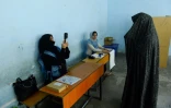 Une employée de la Commission électorale scanne le visage d'une votante lors des législatives, le 20 octobre 2018 à Hérat, en Afghanistan