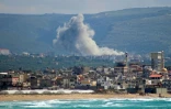 Photo prise depuis la région de Tyr, dans le sud du Liban, montrant de la fumée s’élevant du site d’une frappe israélienne ayant visé le village de Qlaileh le 11 avril 2026