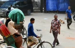 Le bourreau Shahjahan Bouya (c) traverse une rue devant l'ancienne prison centrale de Dacca  où il a purgé la majeure partie de sa peine de prison, le 20 octobre 2023 au Bangladesh