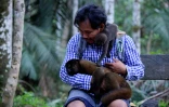 Un singe laineux et un bébé dans les bras de Jhon Jairo Vasquez, fondateur du refuge de Maikuchiga, le 18 novembre 2020 près de Leticia, en Amazonie colombienne
