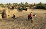 Des enfants se déplacent à dos d'âne dans les vieux murs de l'oasis de Fachi, au Niger, le 24 mai 2023