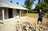 Dipak Magar devant la maison qu'il a construite avec l'argent gagné à l'étranger, le 12 décembre 2025 à Madi, au Népal