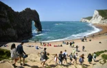 Des touristes prennent le soleil sur une plage de Durdle Door, près de West Lulworth, le 24 mai 2020 dans le sud de l'Angleterre