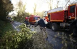 Le président Emmanuel Macron avec des pompiers lors d'une visite dans une région touchée par la tempête Ciaran à Plougastel-Daoulas, dans le Finistère, le 3 novembre 2023