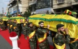 Des membres du Hezbollah portent les cercueils de trois de leurs camarades tués en Syrie en combattant au côté du régime, lors de funérailles à Nabatiyeh dans le sud du Liban le 8 novembre 2017 