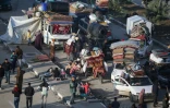 Des déplacés palestiniens  attendent près du passage de Netzarim, qui coupe la bande de Gaza en deux, avant de pouvoir regagner le nord du territoire, le 26 janvier 2025
