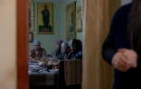 Des fidèles prennent un repas après la messe du matin dans l'église orthodoxe de Bilytske, dans la région de Donetsk, le 3 mars 2025 en Ukraine