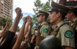 Des femmes vêtues de noir en signe de deuil font face à des policiers,le 1er novembre 2019 à Santiago du Chili