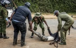 Des policiers transportent un manifestant grièvement blessé et inanimé lors d'affrontements au cours d'une manifestation contre un centre de quarantaine Ebola construit par les États-Unis sur la base aérienne de Laikipia, le 9 juin 2026 à Nanyuki, au Kenya