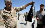 Un soldat syrien brûle un drapeau de l'Etat islamique (EI), le 4 avril 2016