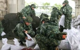 Des soldats préparant des sacs de sable avant l'arrivée du typhon Kong-rey dans le comté de Yilan, à Taïwan, le 30 octobre 2024 