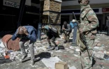 Pillards arrêtés par la police et l'armée sud-africaines devant un centre commercial à Soweto, en banlieue de Johannesbourg, le 13 juillet 2021 