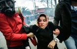 Des journalistes portent une femme blessée après des tirs de grenades lacrymogènes par la police anti-émeutes turque pour disperser une manifestation de soutien au quotidien Zaman, le 5 mars 2016 à Istanbul