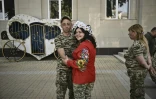 Les militaires ukrainiens Kristina Liouta (à droite) et Volodymyr Mykhalchouk durant leur mariage dans la ville de Droujkivka, dans l'est de l'Ukraine, le 12 juin 2022