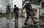 Des habitants nettoient les débris dans une rue inondée de Villeneuve-Saint-Georges le 25 janvier 2018