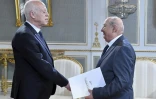 Le juriste tunisien Sadok Belaïd (d), chargé d'élaborer la nouvelle Constitution, présente un projet de texte au président Kais Saied (g) à Tunis le 20 juin 2022