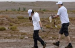 Des bénévoles ramassent des déchets lors d'une campagne de nettoyage de M'Hamid El Ghizlane, aux portes du désert, dans le sud Maroc, le 12 avril 2025