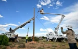 Des ouvriers plantent un poteau électrique à Tonalea, en Arizona, le 8 juillet 2025, dans le cadre d'un projet pour électrifier la réserve amérindienne Navajo