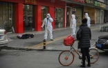 Les services de secours interviennent après le décès d'une personne (au sol) dans une rue de Wuhan, le 30 janvier 2020
