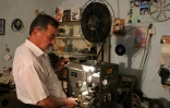 L'Irakien Abdel Qader al-Ayoubi met en marche un projecteur dans son sous-sol, transformé en musée du septième art, à Kirkouk, le 27 juillet 2018