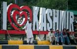 Des travailleurs assis au bord d'une route à Muzaffarabad, la capitale du Cachemire contrôlé par le Pakistan, le 30 avril 2025