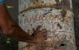 Le travailleur agricole Pedro Fletes montre des bidons rouillés, qui contenaient le pesticide DBCP, le 11 mai 2022 à Tonala, au Nicaragua
