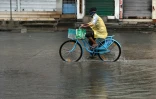 Un habitant à vélo dans une rue inondée à Kakinada, alors que le cyclone Arnab toutche terre, le 28 octobre 2026 dans l’État de l’Andhra Pradesh, en Inde