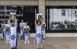 Des manifestants drapés de drapeaux israéliens tiennent des portraits d'otages détenus à Gaza depuis les attaques du 7 octobre, appelant à leur libération devant le Musée d'art de Tel-Aviv, désormais officieusement appelé "Place des otages", à Tel-Aviv le 16 décembre 2023