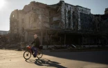 Un habitant  passe à vélo devant un restaurant détruit dans la ville de Pokrovsk, dans la région de Donetsk, le 19 novembre 2024