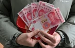 Wang Yanlong montre les 1.500 yuans (197 euros) qu'il a reçus du gouvernement local après son mariage début janvier, dans un bureau administratif de Lüliang, dans la province du Shanxi, dans le nord de la Chine, le 11 février 2025