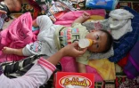 Un bébé boit du lait dans un centre pour personnes déplacées à Carita, dans la province de Banten, le 24 décembre 2018 en Indonésie