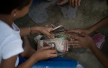 Enfants jouant avec des billets de bolivar vénézuélien à Puerto Concha le 9 septembre 2021