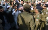 Des policiers empêchent des hommes de groupes conservateurs de se mêler à une manifestation de femmes à Lahore (Pakistan) lors de la journée internationale des droits des femmes, le 8 mars 2022