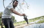 Desalegn Regassa, cadre de l'ONG Wetlands International, montre une jacinthe d'eau collectée sur les rives du lac Dembel, l'un des lacs de la vallée du Rift central en Éthiopie, longtemps touché par la surexploitation et la pollution, le 20 mai 202 5à Batu