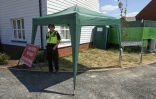 Des policiers montent la garde devant une maison à Amesbury dans le sud de l'Angleterre, le 8 juillet 2018