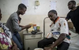 Beckley Motome reçoit l'aide de sa famille pour manger sur son lit d'hôpital de Buea, le 4 octobre 2018
