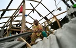 Une femme assise le 28 mai 2024 dans sa maison soufflée par le cyclone Remal à Patuakhali, au Bangladesh