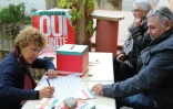 Une femme signe le registre des votants après avoir voté au référendum organisé par le PS, à Cintegabelle, le 18 octobre 2015