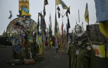 Une statue religieuse parmi les drapeaux de brigades ukrainiennes devant un panneau indiquant la frontière de la région de Donetsk, le 25 janvier 2025 en Ukraine