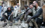 Des bénévoles du service de défense civil syrien se reposent après un bombardement dans un quartier rebelle d'Alep, le 23 avril 2016