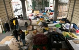 Photo prise le 23 mars 2016 montrant des migrants originaires d'Afghanistan, du Soudan, de Somalie, d'Erythrée installés dans un campement sous la métro aérien près de la station Stalingrand à Paris 