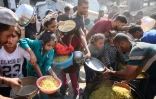 Des déplacés palestiniens dont des enfants se rassemblent pour recevoir des rations alimentaires dans le quartier de Zeitoun à Gaza-ville, le 23 octobre 2025