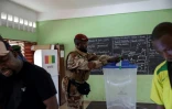 Un soldat guinéen dépose son bulletin dans une urne d'un bureau de vote dans une école de Conakry, le 21 septembre 2025, lors d'un référendum constitutionnel en Guinée.