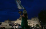 Une femme brandit un drapeau argentin devant le Congrès après que les députés ont suspendu le débat sur les réformes dérégulatrices du président ultralibéral Javier Milei, à Buenos Aires, le 6 février 2024